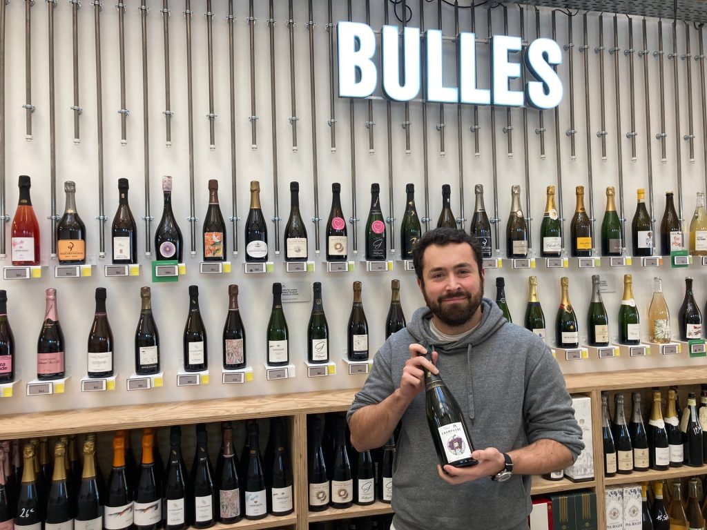 Jean-Baptiste, mananger des boutiques de La Nouvelle Cave avec l'un de ses champagnes favoris.